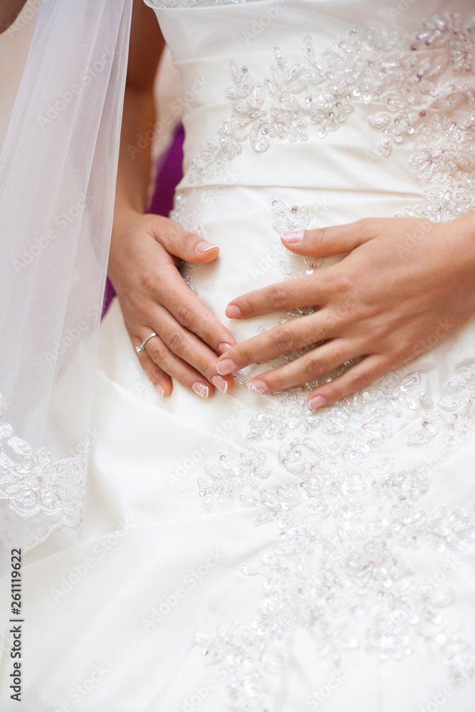 bride holds hands on stomach. wedding day. bride holds hands on stomach. wedding day.