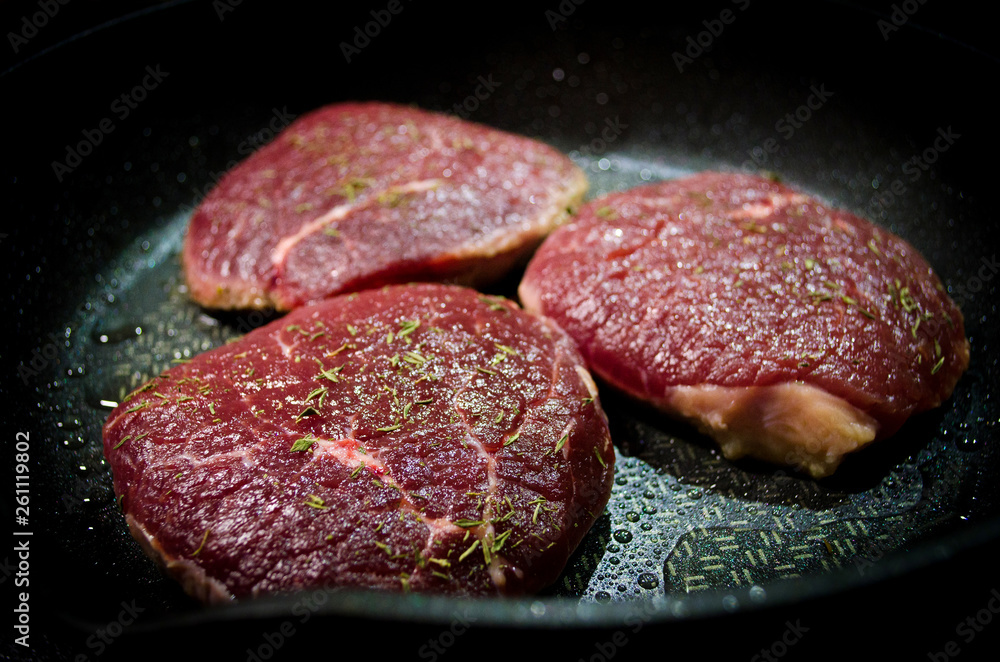 Raw beef steaks on the grill Raw beef steaks on the grill