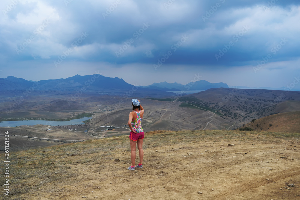 Girl looking at the mountain landscape in the desert Girl looking at the mountain landscape in the desert