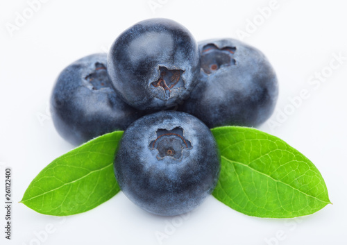 Fresh raw organic blueberries with leaf on white background. Macro close up