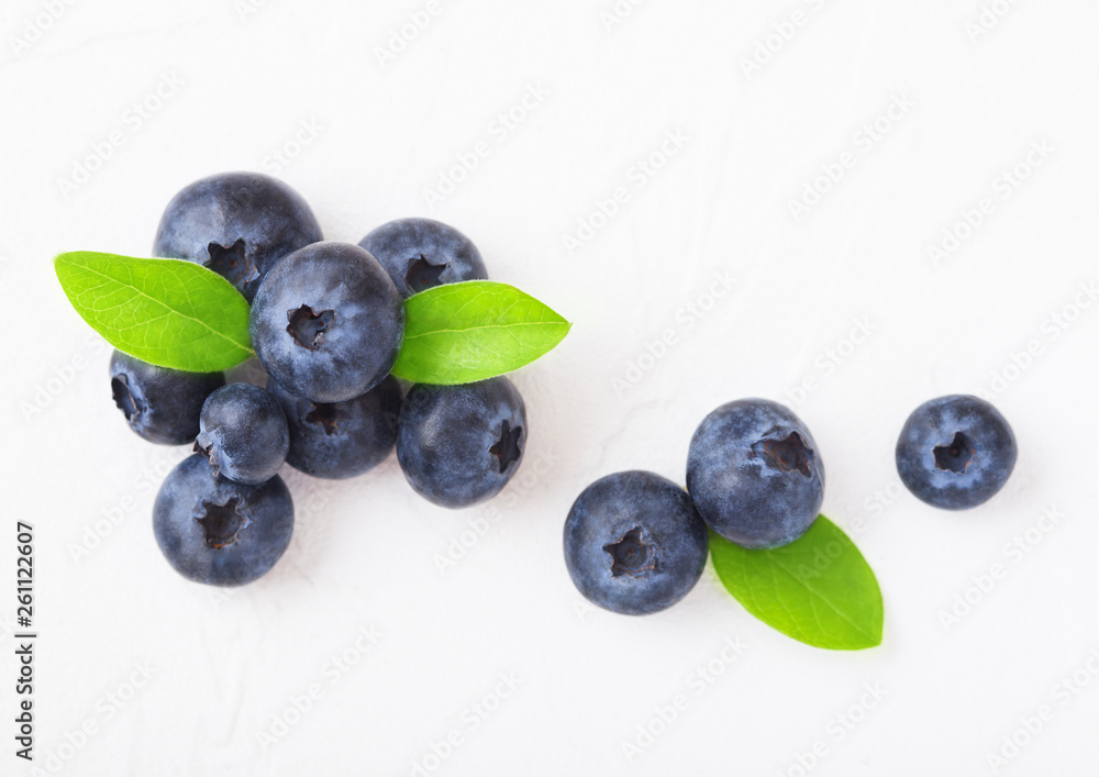 Fresh raw organic blueberries with leaf on white background. Macro close up Fresh raw organic blueberries with leaf on white background. Macro close up