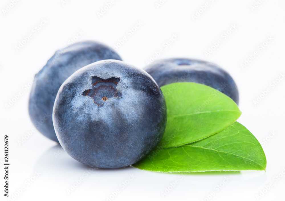 Obraz premium Fresh raw organic blueberries with leaf on white background. Macro close up