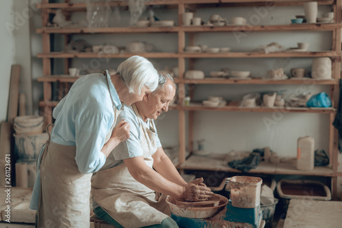 Senior couple enjoying of work with wet clay in workshop