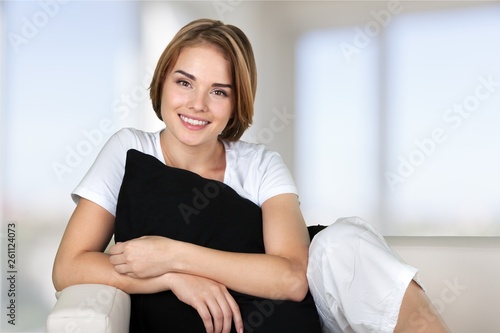 Brunette woman sneezing in a tissue in the living room