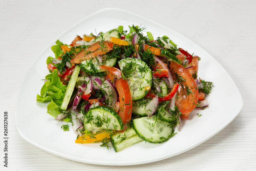 rustic salad of fresh cucumbers, tomatoes and onions, decorated with greens, on plate rustic salad of fresh cucumbers, tomatoes and onions, decorated with greens, on plate