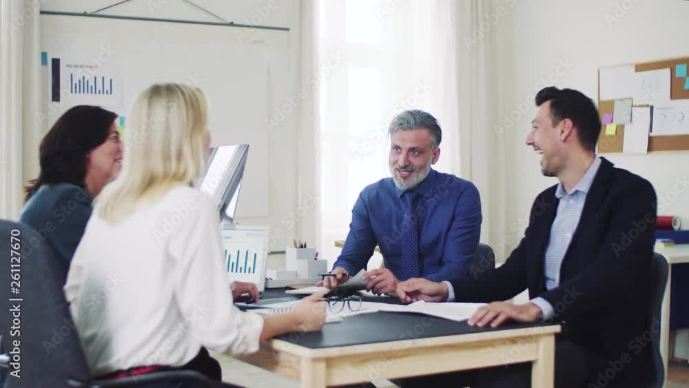 Group of young and old businesspeople with laptop working together in office. Group of young and old businesspeople with laptop working together in office.