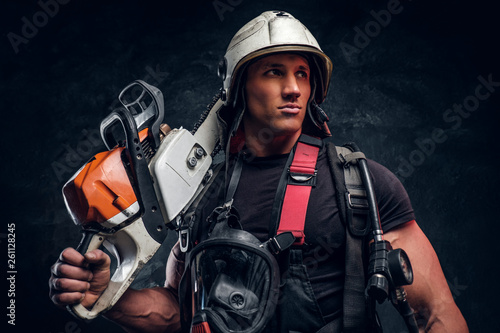 Portrait of muscular man with chainsaw and respirator