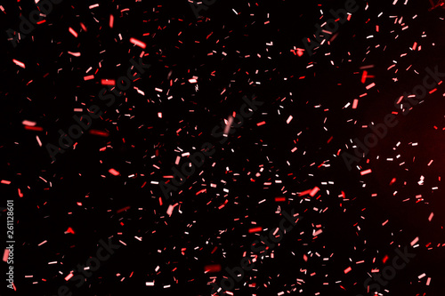 Thousands of confetti fired on air during a festival at night. Image ideal for backgrounds. Red are the confetti in the picture. The sky as background is black
