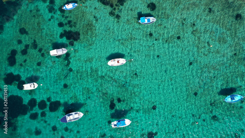 Aerial drone bird's eye view photo of traditional docked fishing boats near Naousa in island of Paros with deep emerald sea, Cyclades, Greece