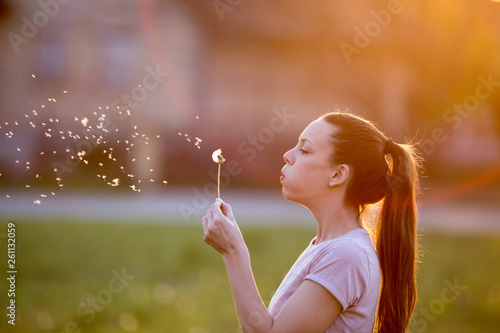 Woman blowing dandelion flower