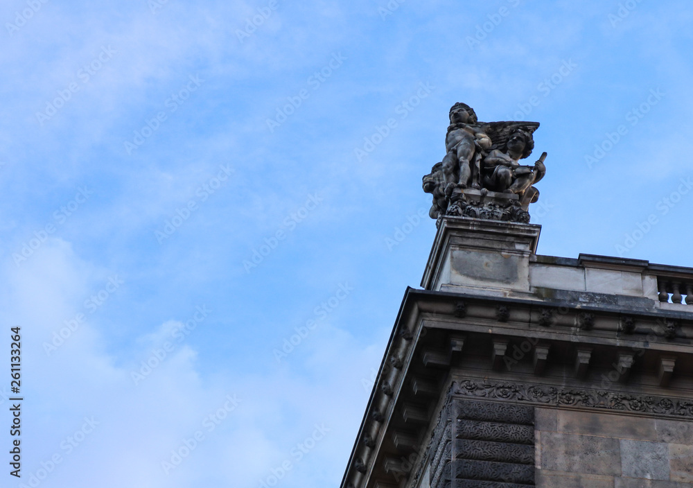 Splendid sculpture and architectural details of historical building on the street of Paris France on a background of blue sky with clouds. Space for your text