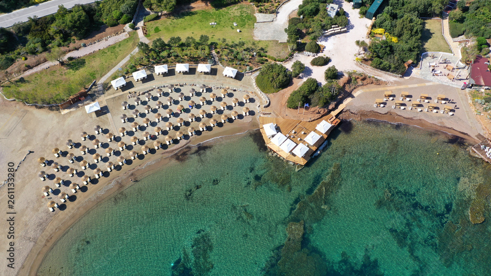 Aerial top view photo of sun beds in tropical paradise deep emerald mediterranean sandy beach