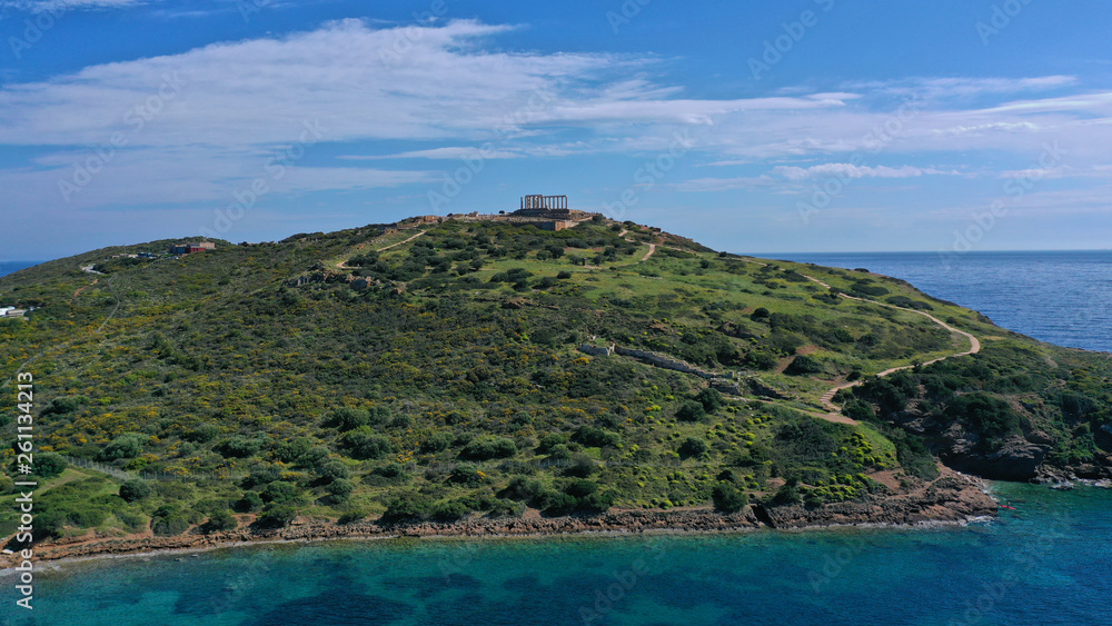 Aerial drone bird's eye view of archaeological site of Cape Sounio and magnificent Ancient temple of Poseidon on top of deep blue bay, South Attica, Greece