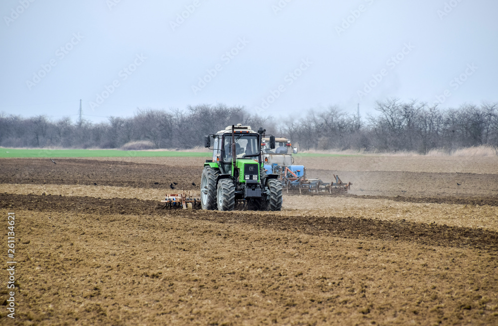 Lush and loosen the soil on the field before sowing. The tractor plows a field with a plow Lush and loosen the soil on the field before sowing. The tractor plows a field with a plow