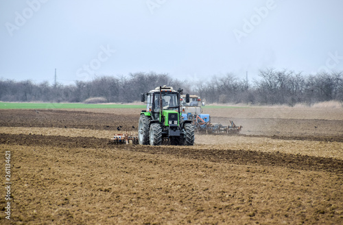 Lush and loosen the soil on the field before sowing. The tractor plows a field with a plow