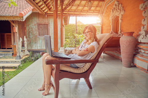 Girl using laptop on a home porch / terrace.