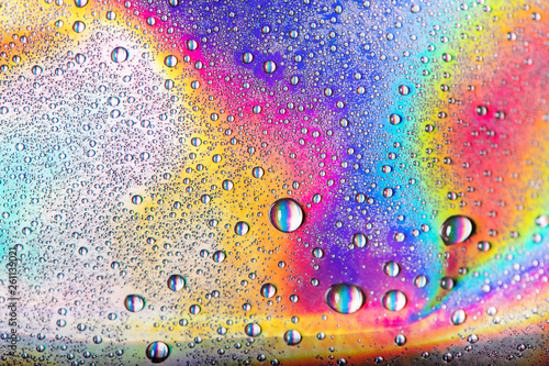 Drops of water on vibrant holographic neon background