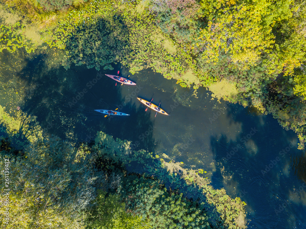 Aerial drone bird's eye view photo of Happy family with two kids enjoying  kayak ride on beautiful river. Little boy and teenager girl kayaking on hot  summer day. Water sport fun. foto
