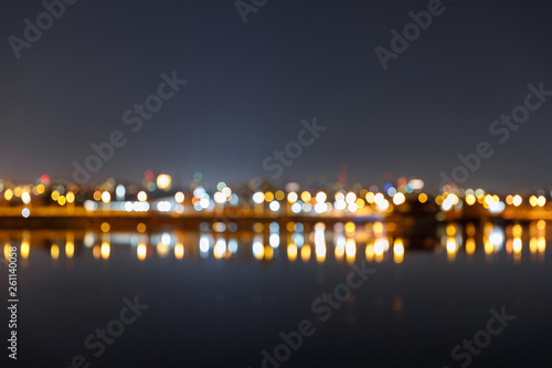 dark cityscape with defocused illuminated buildings and river
