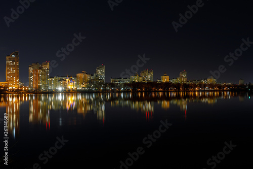 picturesque dark cityscape with illuminated buildings, river and night sky © LIGHTFIELD STUDIOS