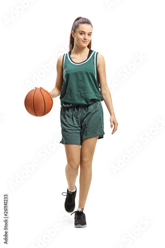 Female basketball player leading a ball and posing