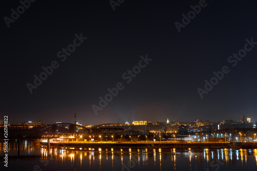 tranquil cityscape with illuminated buildings and reflection on river at night