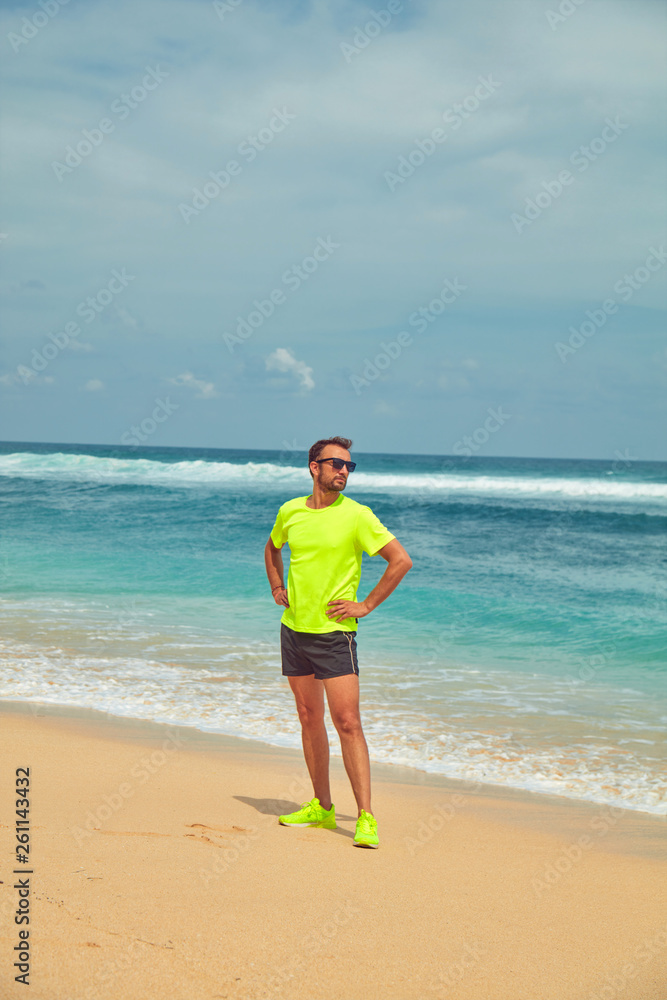 Sportsman stretching on a tropical sandy beach. Sportsman stretching on a tropical sandy beach.