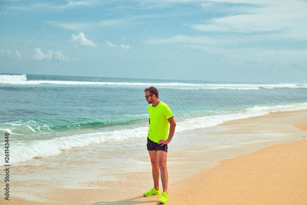 Sportsman stretching on a tropical sandy beach. Sportsman stretching on a tropical sandy beach.