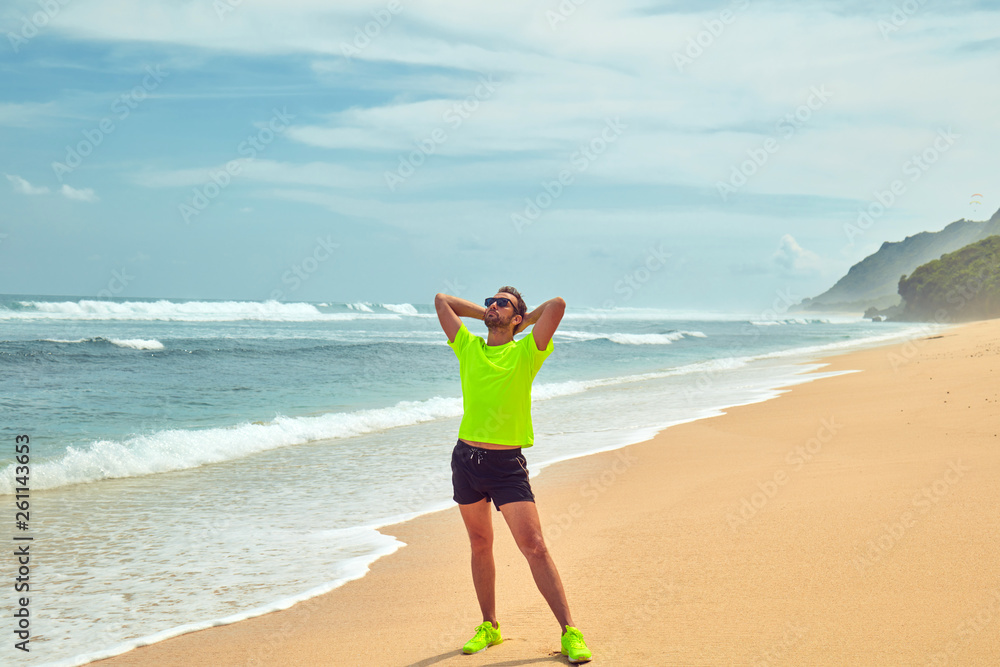 Sportsman stretching on a tropical sandy beach. Sportsman stretching on a tropical sandy beach.