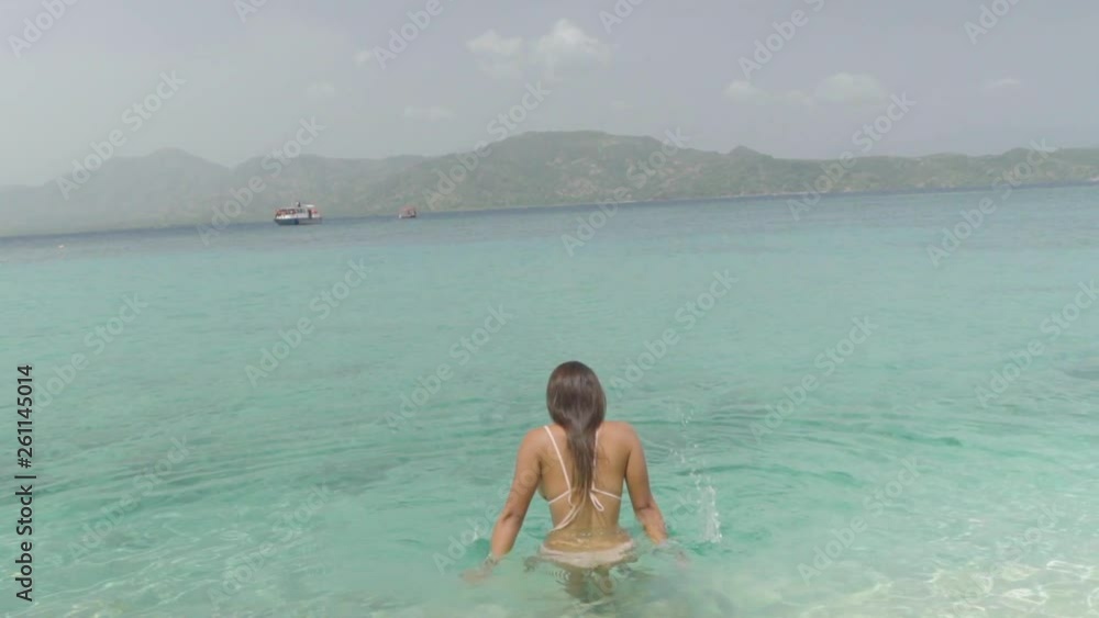 Slow Motion: A Bikini-Clad Young Woman Plays in the Crystal Blue Ocean in Chouchou Bay, Haiti Slow Motion: A Bikini-Clad Young Woman Plays in the Crystal Blue Ocean in Chouchou Bay, Haiti