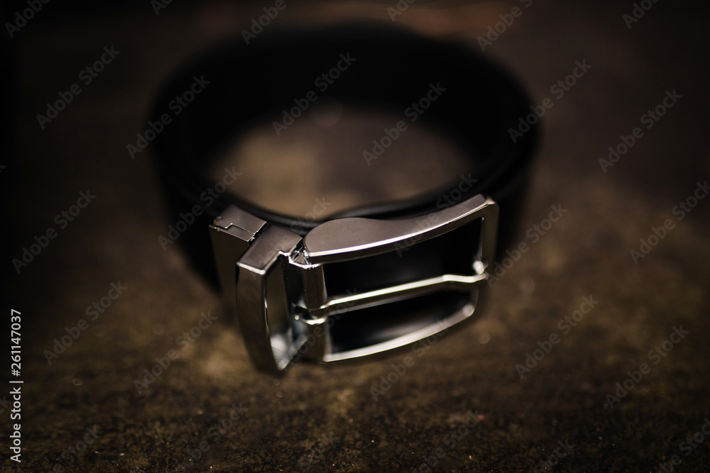 men's black uniform for pants. black leather belt. fashion leather belt on wooden background with steel metal buckle men's black uniform for pants. black leather belt. fashion leather belt on wooden background with steel metal buckle