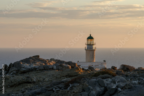 Lighthouse on Rhodes island in Greece on the rocky shore of Cape Prasonisi at sunset close-up