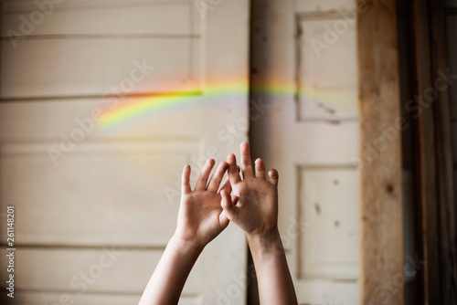 kids hands reaching for rainbow photo