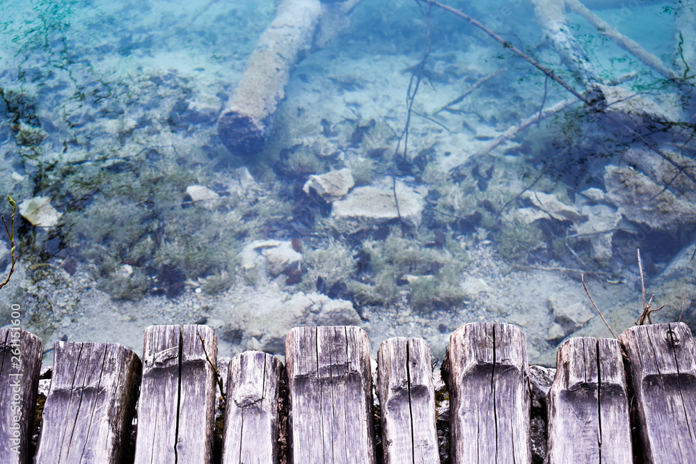 Fototapeta premium View at crystal clear blue water from wooden boardwalk
