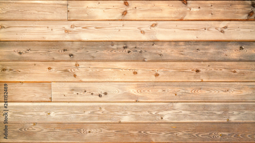 Naklejka premium Warm brown wood surface with aged boards lined up. Wooden planks on a wall or floor with grain and texture. 
