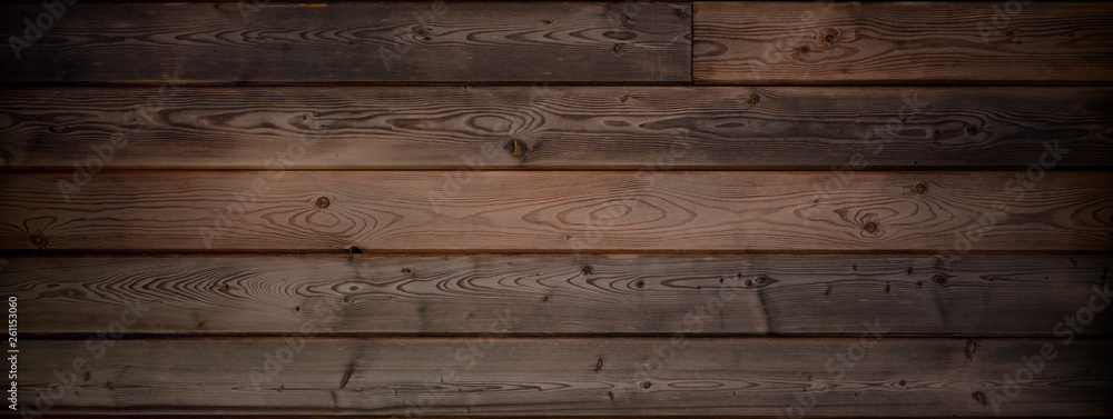 Fototapeta premium Dark warm brown wood surface with aged boards lined up. Wooden planks on a wall or floor with grain and texture. 