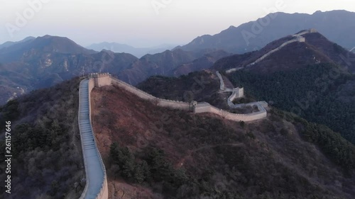 Quick aerial shot of Badaling Great Wall of China at evening time. Stone wall follow wavy terrain at highland, ancient fortification structure at Yanqing District, Beijing photo