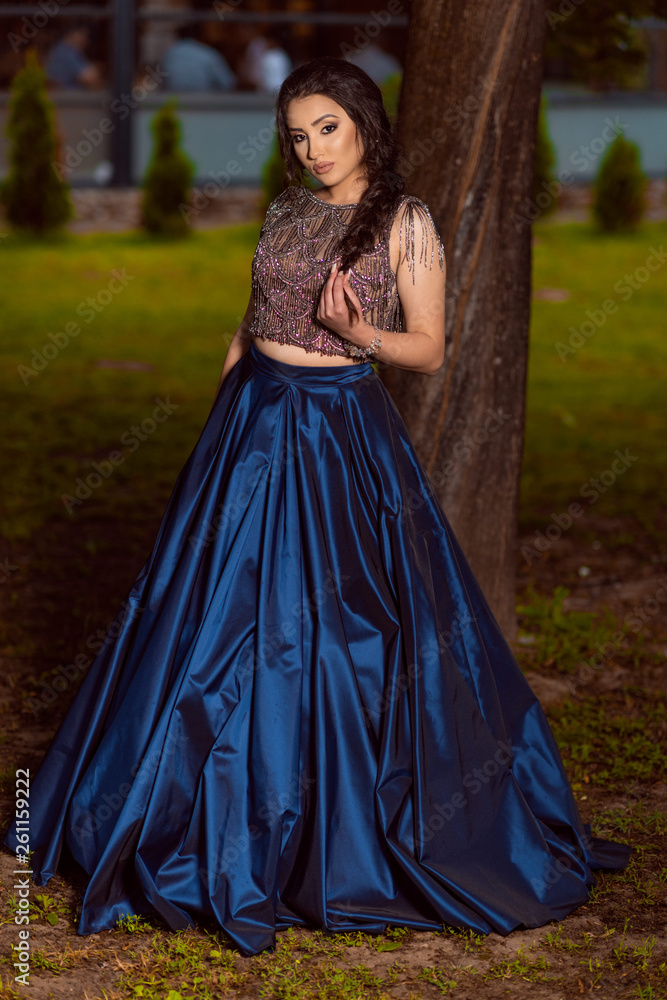 Fototapeta premium Beautiful young lady in luxury blue dress for her prom night