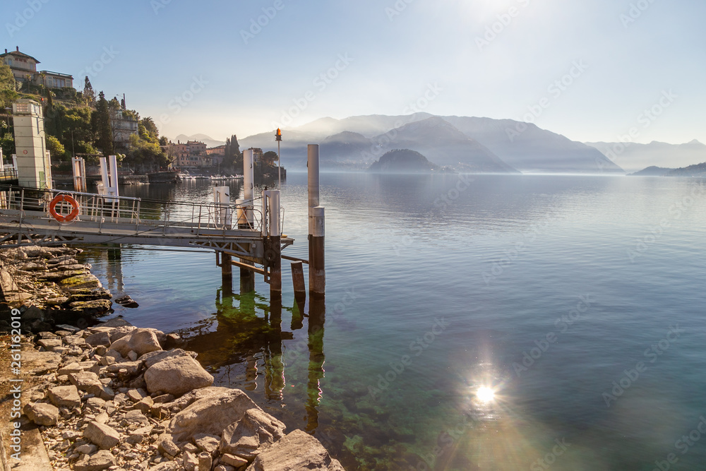 View on a wooden dock in Como Lake in front of Bellagio and the near hills. Varenna, Italy