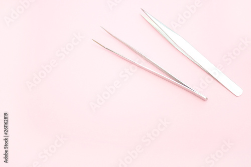 tools for Eyelash Extension Procedure. Two tweezers on pink background. copyspace mockup - Beauty and fashion concept