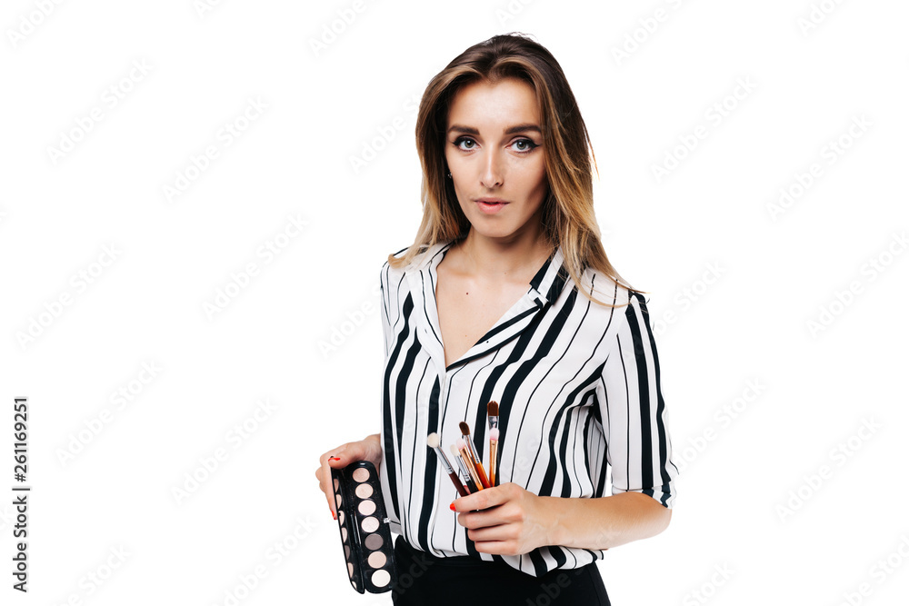 girl makeup artist on a white background holding a small eye shadow brushes and a palette girl makeup artist on a white background holding a small eye shadow brushes and a palette