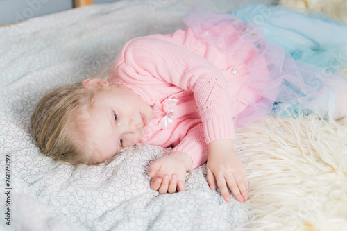 Little girl falls asleep on the bed.