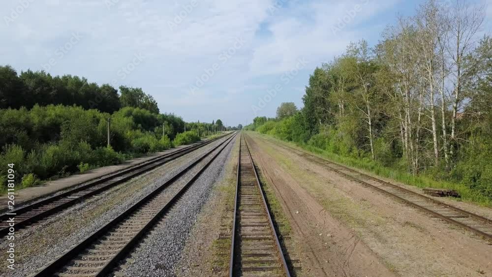 Spectacular scenery of empty long railways laying between green line of bushes and trees at some suburb area on warm summer sunny day in the countryside. Spectacular scenery of empty long railways laying between green line of bushes and trees at some suburb area on warm summer sunny day in the countryside.