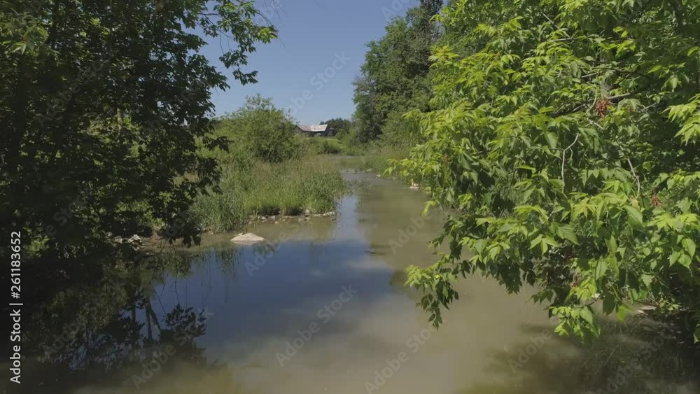 aerial fly low over stream leading to farm in distance aerial fly low over stream leading to farm in distance