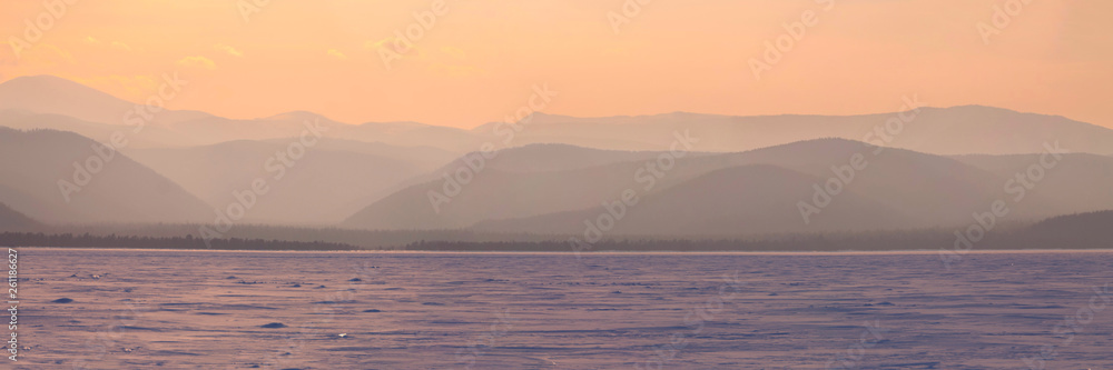 Wide angle panorama winter mountain,misty hills mountain tops in pink dawn