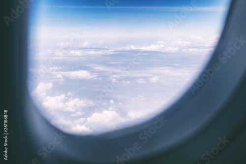 Aircraft wing and blue sky on cloudy day through the window