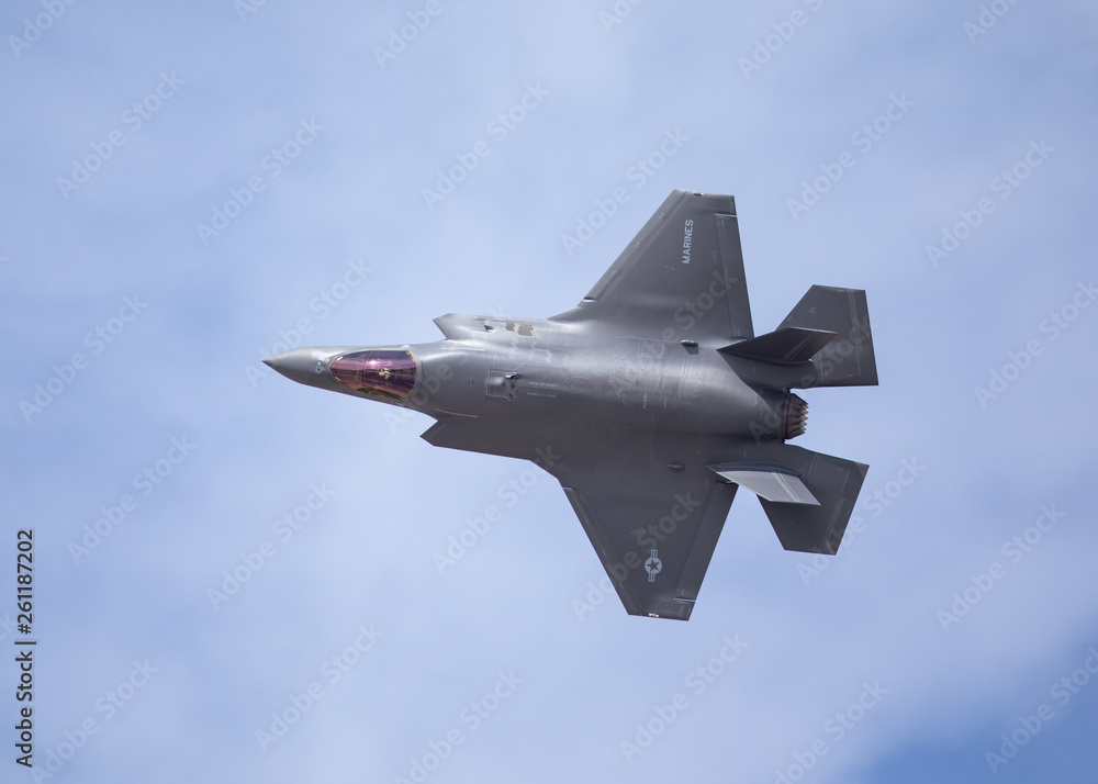 Very close top view of an F-35 Lightning II  against the cloudy sky - obrazy, fototapety, plakaty 