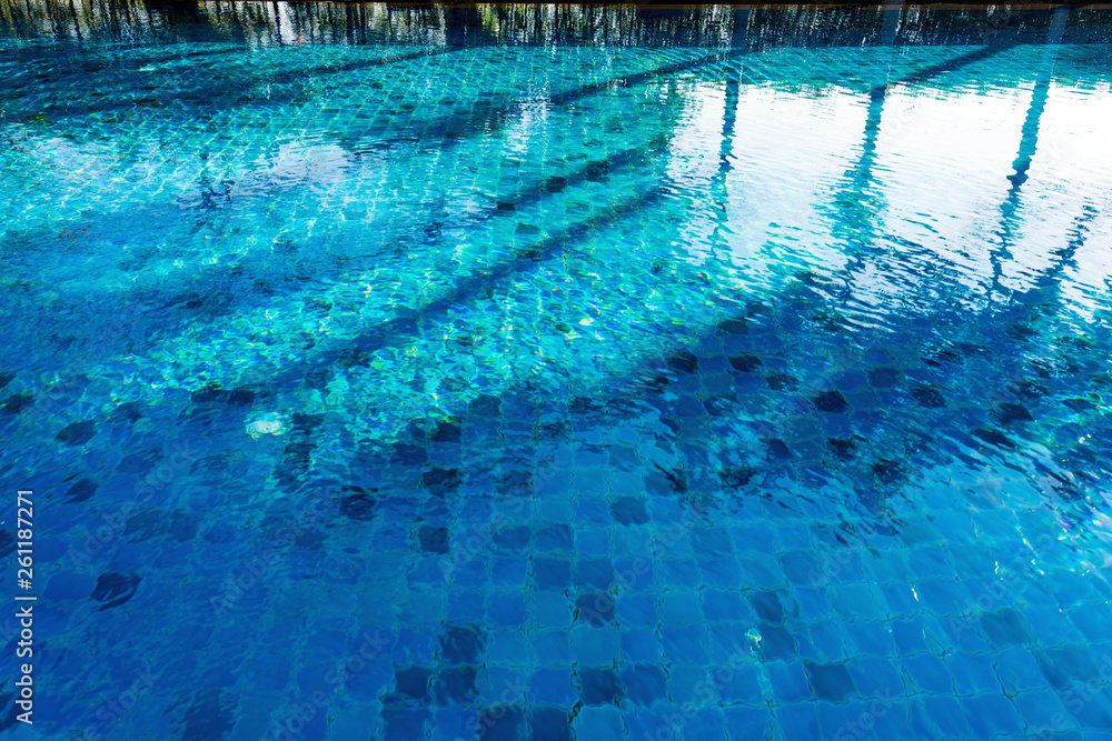 Reflection and shadow of trees on blue swimming pool