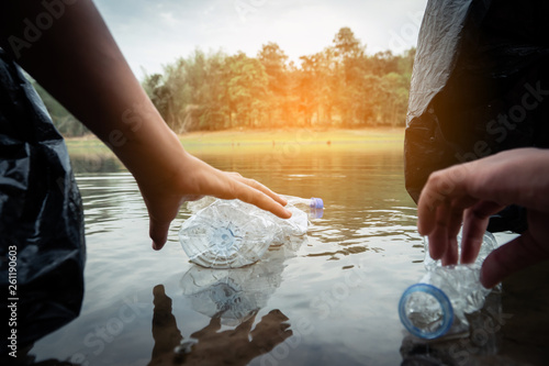 The volunteer picking up a bottle plastic in the river   protect environment from a water pollution concept.