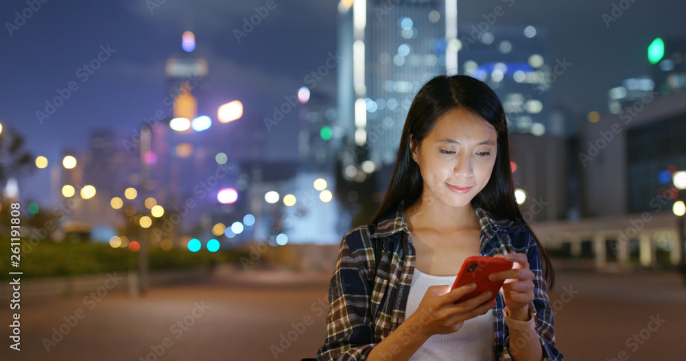 Fototapeta premium Woman use of smart phone city night